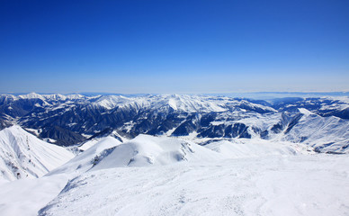 Fototapeta na wymiar Georgia, mountains view with deep blue sky, white snowy landscape, picturesque scenery, ski resort in Caucasus, Gudauri