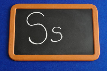 A black board with the alphabet letter S in a capital and small letter