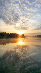 Fototapeta na wymiar Sunrise on the forest lake