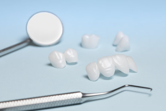 Dental tools and dentures on a light blue background - Ceramic veneers - lumineers