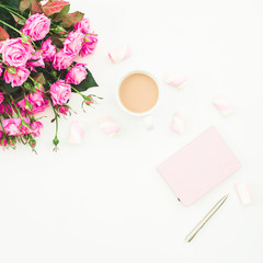 Female desk with pink roses bouquet, pink diary, coffee mug and marshmallows on white background. Flat lay. Top view feminine background. Fashion blog.