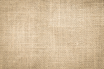 Jute hessian sackcloth woven burlap texture pattern background in old aged yellow beige cream gold...