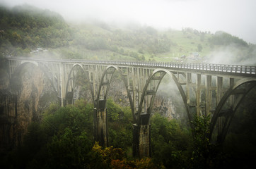 красивый мост в призрачной дымке на фоне гор