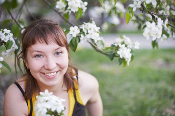 Fototapeta premium Spring. Portrait of a young girl. White flowers of an apple tree