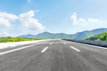green mountain and empty asphalt highway natural scenery under the blue sky
