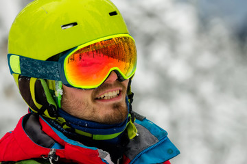Portrait young man ski goggles holding ski in the mountains