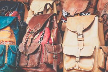 Moroccan leather goods bags and slippers at outdoor market in Marrakesh, Morocco.