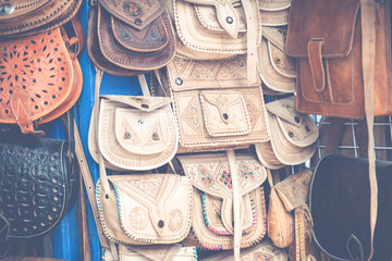 Moroccan leather goods bags and slippers at outdoor market in Marrakesh, Morocco.