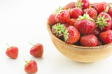 many berries ripe juicy strawberries in a wooden plate