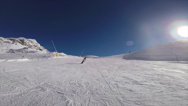 boy with snowboard on the ski slope overtakes me fast. Pov with camera on my back
