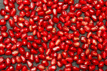 Pomegranate seeds close-up on dark concrete background