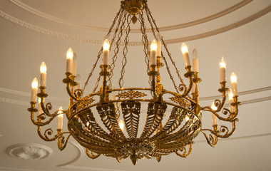 Luxury chandelier with candles hanging on the ceiling