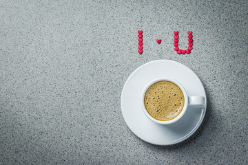 A cup of coffee "I love you" sign on concrete background. St. Valentine's day concept. Top view, copy space.