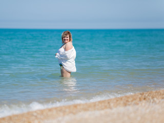 Fototapeta na wymiar Overweight woman in white stands in water