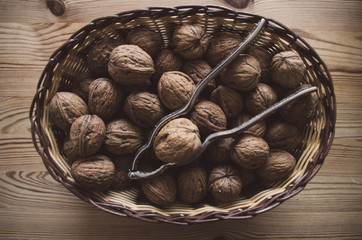 Walnuts with nutcracker in a bowl.