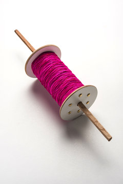 Wooden Spool or chakri/reel/fikri with pink or white thread, isolated over white background