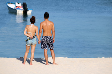 Asian couple enjoy the ocean view on the beach