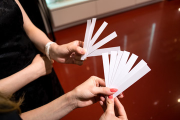 Young women,only hands to be seen, hold paper testers for perfume