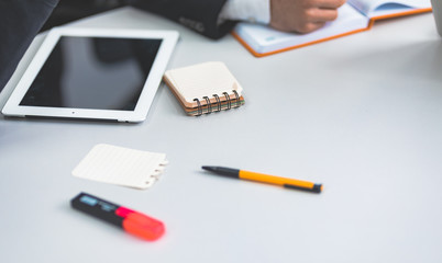 Empty notebook with tablet and two pen on wooden table top view.