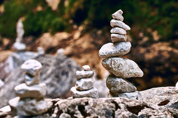 Zen-like pyramid of stones in perfect balance on the rocky mountains stream shore