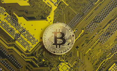 gold bitcoin concept - computer circuit board with bitcoin processor and microchips. Electronic...