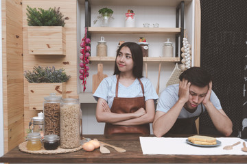 Young white man in kitchen with his chinese girlfriend trying to think about what to cook for dinner. Young couple living together before marrige concept.