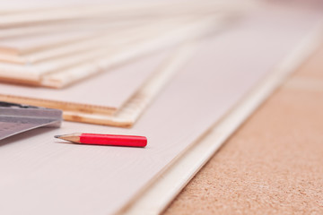 Obraz premium Carpentry pencil and a square on the boards during work, carpentry work on the device of the floor, selective focus.