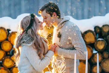 Winter portrait of bride and groom. Beautiful couple in knitted warm clothes. Artwork