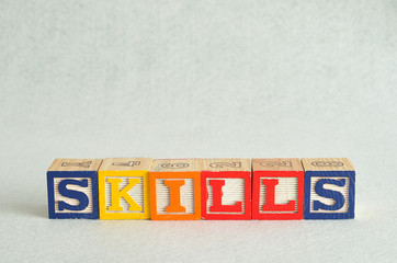 The word skills spelled with colorful blocks isolated on a white background
