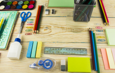 Frame with school supplies on a wooden background. Flat lay, top view