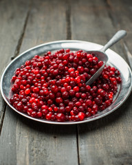 Christmas card. Frozen Red cranberries in the iron plate on a wooden background. Winter postcard. Place for your text and greetings