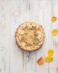 Autumn background with pumpkin pie, hot tea, yellowed leaves, book and rug. Perfect sunny autumn. A wooden light white autumn background for you. Copy Space. Place for text. Flat lay, top view