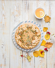 Autumn background with pumpkin pie, hot tea, yellowed leaves, book and rug. Perfect sunny autumn. A wooden light white autumn background for you. Copy Space. Place for text. Flat lay, top view