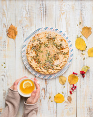 Autumn background with pumpkin pie, hot tea, yellowed leaves, book and rug. Perfect sunny autumn. A wooden light white autumn background for you. Copy Space. Place for text. Flat lay, top view