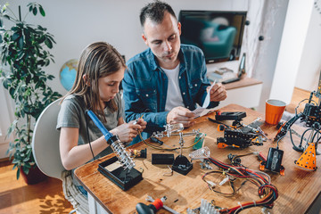 Father and daughter working on electronics components