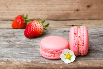 Homemade strawberry macaroons on wooden background.
