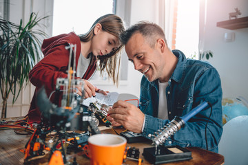 Father and daughter building robot and having fun