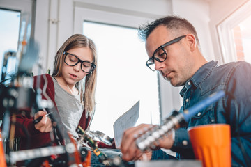 Father and daughter working together in workshop