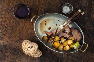 Beef steak fried pumpkin frying pan with wine. Dinner table