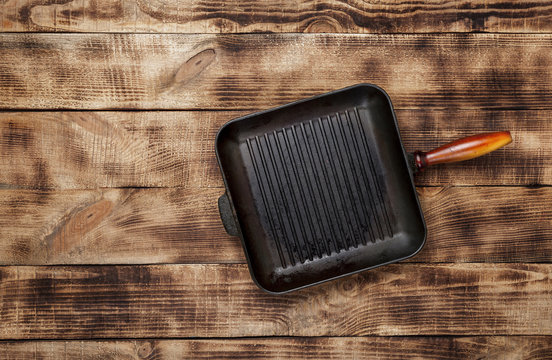 Top view old grill pan on wooden background