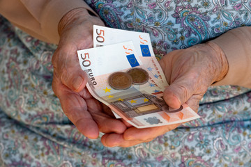 Elderly caucasian woman holding money in her hands