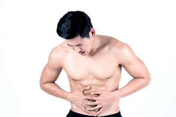 Fototapeta na wymiar Fitness and health concept. Fit sport man having stomach pain, isolated on white background in studio. Half naked Asian chinese lean muscular male wearing a black shorts.