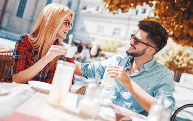 Romantic couple drinking coffee and lemonade, having a date in the cafe. Dating, love, relationships