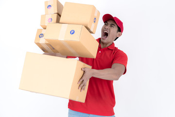 Happy delivery man carry too much boxes and about to drop them. Isolated on white background. Asian chinese fit man in red polo shirt and jeans with red hat in his early twenties.
