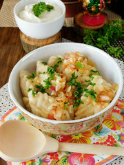 Vareniki with potatoes covered with cracklings and onion in a bowl. Slavic traditional dish