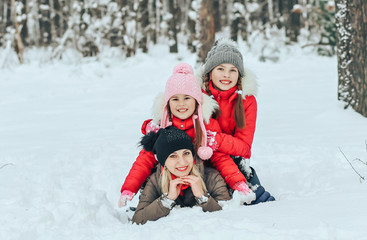 Fototapeta na wymiar Mom and her children playing in the snow in the winter