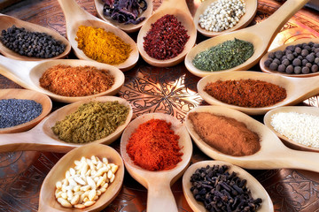 Spices and herbs in wooden spoons.