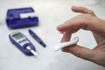 A medical test, checking a drop of blood on the sugar level.