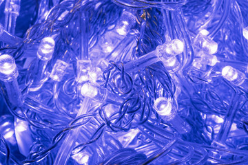 Blue lights on the Christmas tree. A glowing garland. Abstract background.
