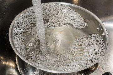 Fliessend Wasser in der Pfanne für die Sauberkeit nach dem Kochen